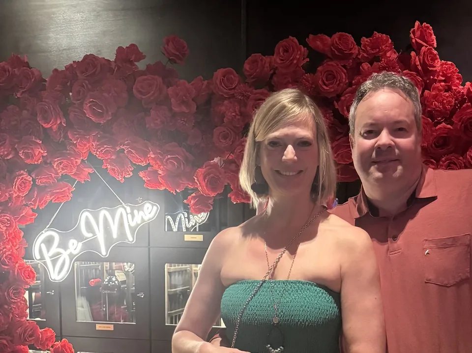 Mark and Jen celebrating Valentine’s Day beside a red rose display